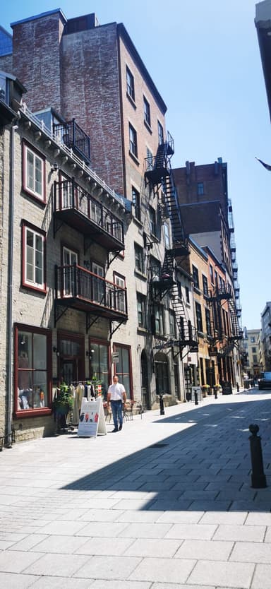 Une rue pavée avec des bâtiments historiques et des balcons en fer forgé.