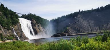 Une vue d'une grande chute d'eau entourée de verdure.
