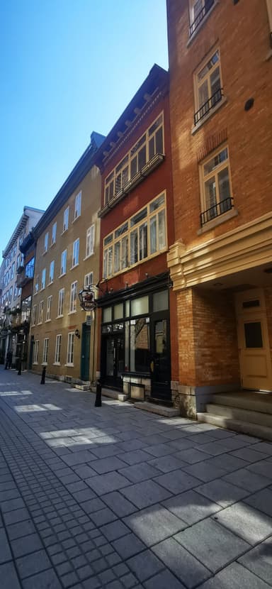 Une rue calme avec des bâtiments colorés sous un ciel bleu.