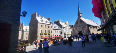 Une rue animée avec des bâtiments historiques sous un ciel bleu.