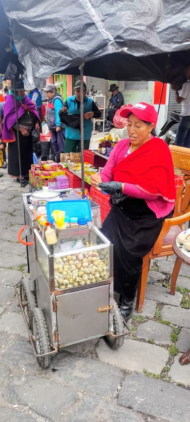 Une femme vend des escargots dans un marché animé.