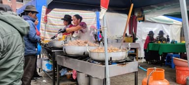 Un marché avec des vendeurs de nourriture et des clients.
