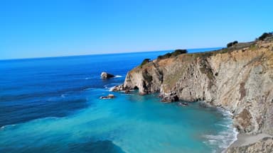 Une vue panoramique de la côte californienne avec des falaises et l'océan bleu.