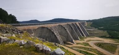Un grand pont en béton surplombant un paysage verdoyant.