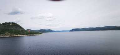 Une vue panoramique sur la rivière avec des collines au loin.
