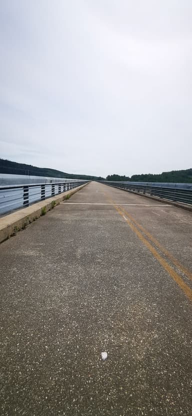 Une route menant au bord de l'eau sous un ciel nuageux.