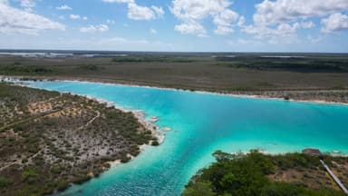 Un paysage naturel avec une eau turquoise et des terres verdoyantes.