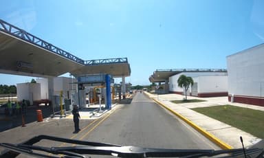 Une route menant à un poste de contrôle à Chetumal, sous un ciel bleu.