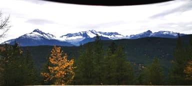 Une vue des montagnes avec des arbres et des nuages.