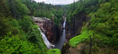 Une vue d'une gorge verdoyante avec une chute d'eau.