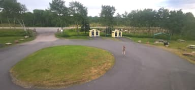 Un espace vert avec des cabines et une personne marchant.