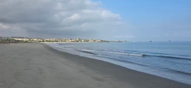 Une plage tranquille avec des vagues et des nuages.