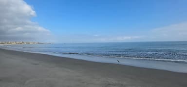 Une plage calme avec un ciel bleu et des vagues douces.