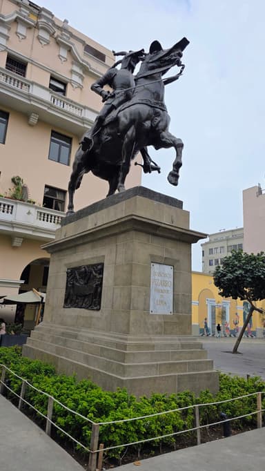 Une statue équestre dans une rue de Lima, sous un ciel nuageux.