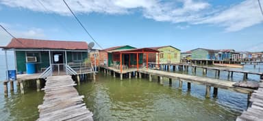 Des maisons colorées sur pilotis au bord de l'eau.