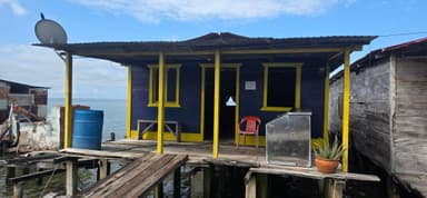 Une maison colorée sur pilotis au bord de l'eau.
