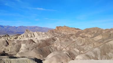 Un paysage désertique avec des collines et un ciel bleu.
