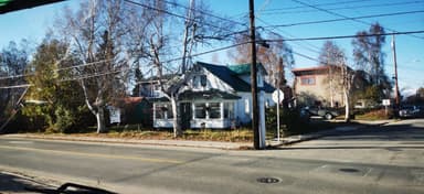 Une maison typique avec des arbres et un ciel bleu à Fairbanks.