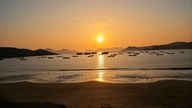 Un coucher de soleil sur la mer avec des bateaux au loin.