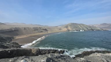 Une vue panoramique de la plage et des collines à Samanco, au Pérou, sous un ciel bleu.