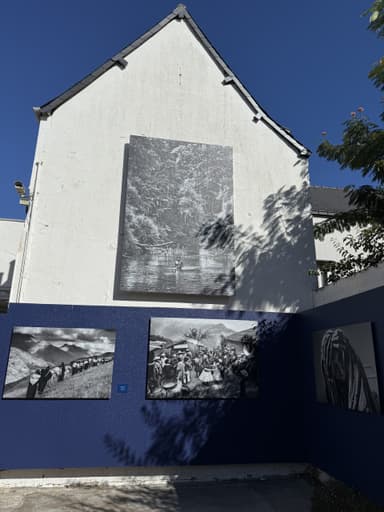 Une façade avec des photos en noir et blanc sur un mur blanc et bleu.