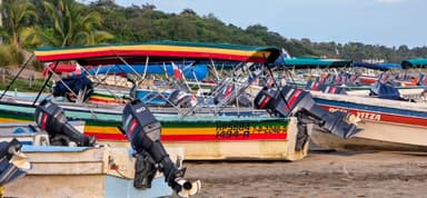 Des bateaux colorés sur une plage à Los Santos, Panama, sous un ciel clair.