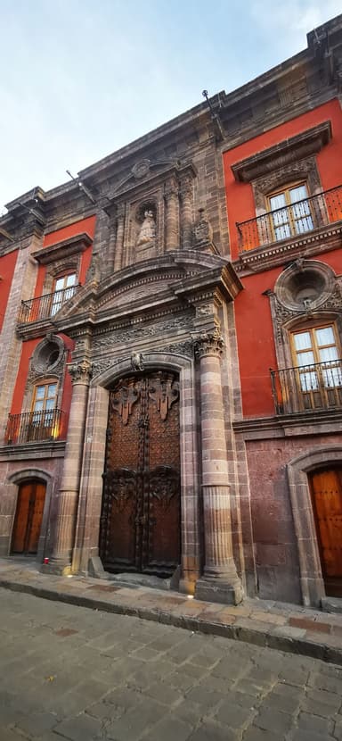 Une façade colorée avec une porte en bois sculpté à Guanajuato.