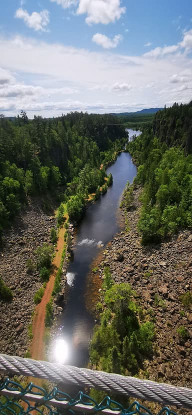 Un paysage naturel avec une rivière entourée d'arbres et de rochers.