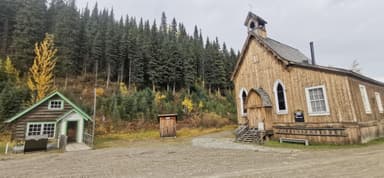 Une scène de bâtiments en bois entourés d'arbres et de feuillage d'automne.