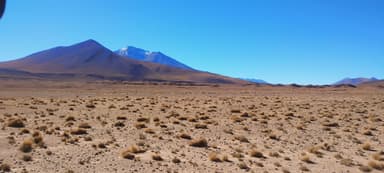 Un paysage désertique avec des montagnes sous un ciel bleu.