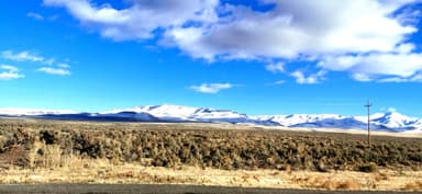 Un paysage de montagnes enneigées sous un ciel bleu.