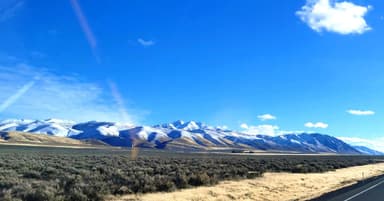 Un paysage de montagnes enneigées sous un ciel bleu.