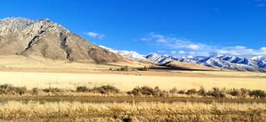 Un paysage de montagnes et de champs à Winnemucca sous un ciel bleu.