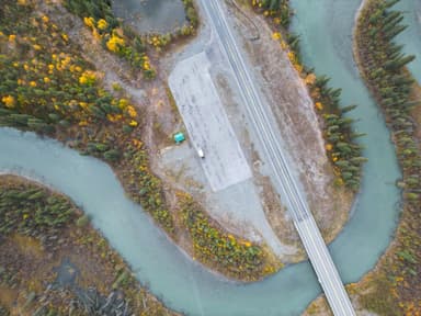 Une vue aérienne d'une route et d'une rivière entourée d'arbres en Alaska.