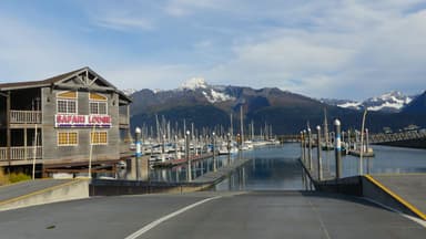 Un paysage de marina avec des montagnes en arrière-plan et un bâtiment en bois.