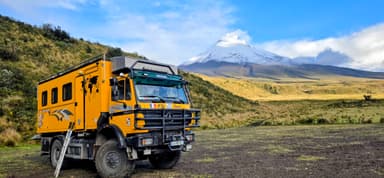 Un camion jaune devant un paysage montagneux en Équateur.