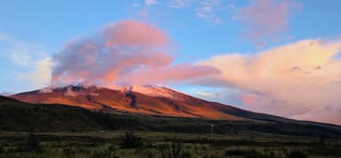 Un paysage de montagne avec des nuages colorés au coucher du soleil.