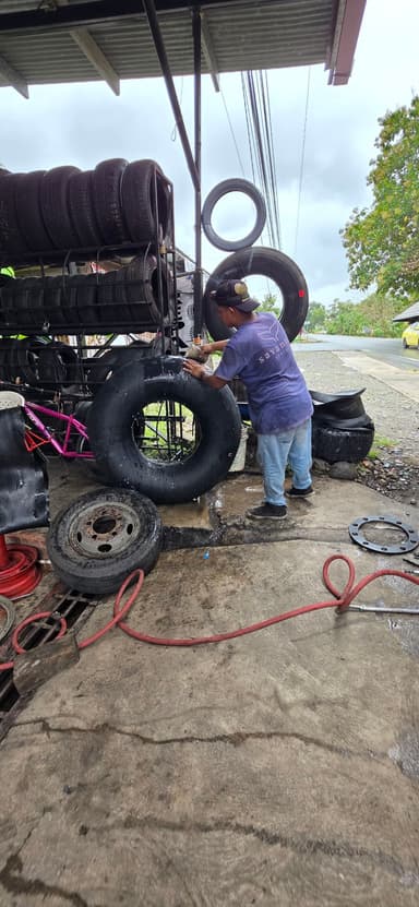 Un homme nettoie un pneu dans un atelier à Jaramillo.