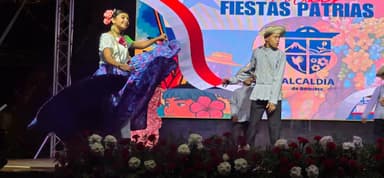 Une danse folklorique avec des costumes colorés sur scène.
