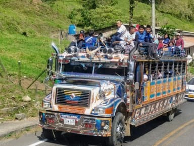 Un bus coloré rempli de passagers sur une route en Colombie.