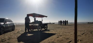 Un vendeur de plage avec un chariot au soleil sur la plage.
