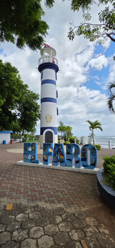 Un phare rayé bleu et blanc avec un ciel nuageux à Managua.