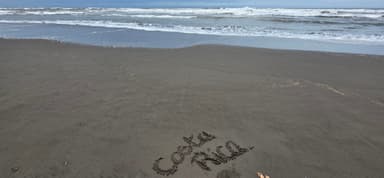 Une plage avec des vagues et des mots écrits dans le sable.