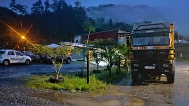 Un camion garé dans une zone rurale sous une lumière tamisée.