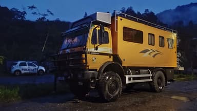 Un véhicule tout terrain jaune stationné dans un paysage nocturne.