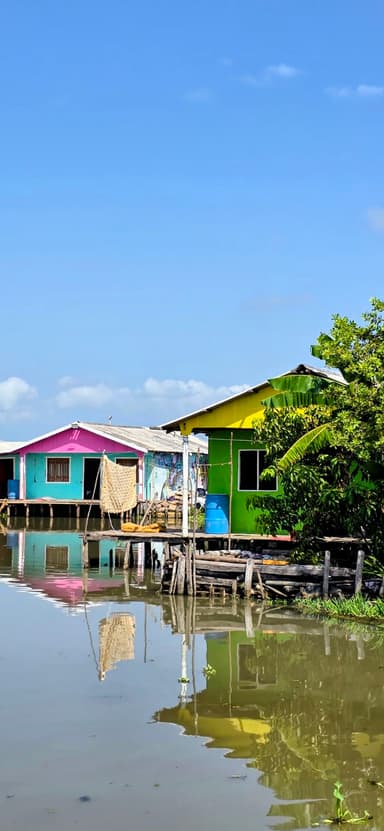 Des maisons colorées au bord de l'eau sous un ciel bleu.