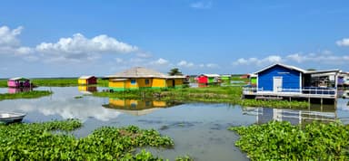 Des maisons colorées sur l'eau sous un ciel bleu.