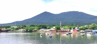 Un paysage de montagne avec des bateaux sur l'eau.