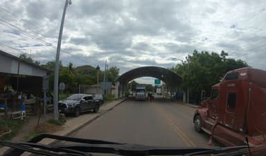 Une route avec des camions et des bâtiments sous un ciel nuageux.