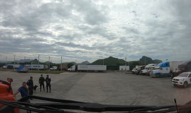 Un paysage de camions et de montagnes sous un ciel nuageux.